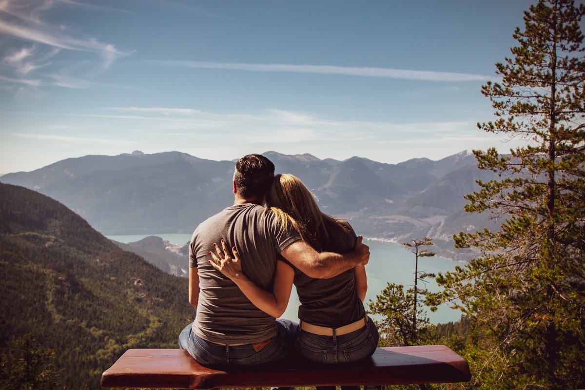 Couple embracing on a mountain overlook - representing true connection and like attracting like in love